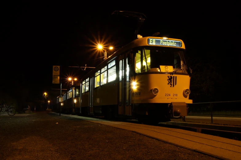 a train engine pulling cars down tracks at night