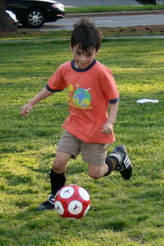 a child in a red shirt playing soccer