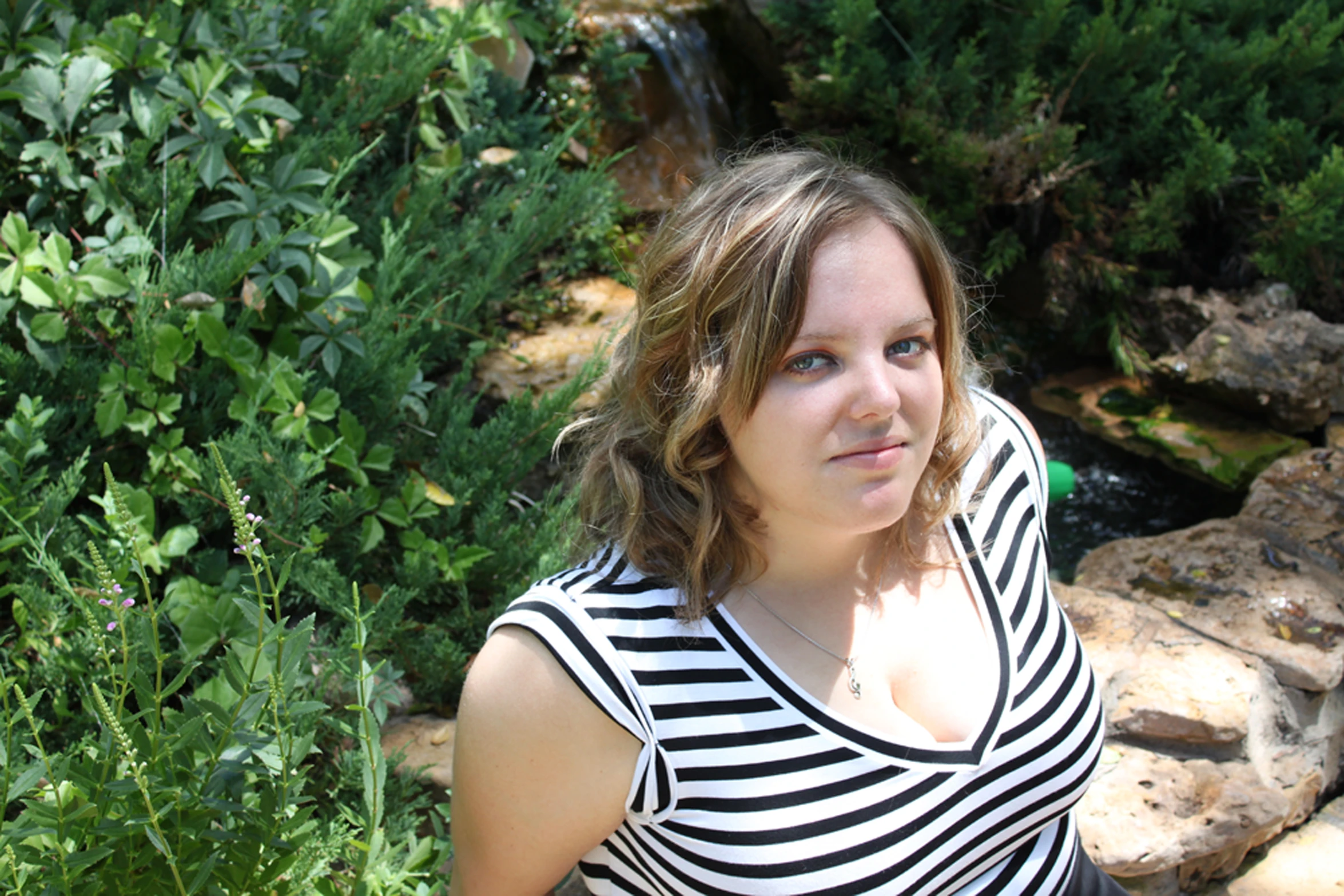 the young woman is posing in the front yard