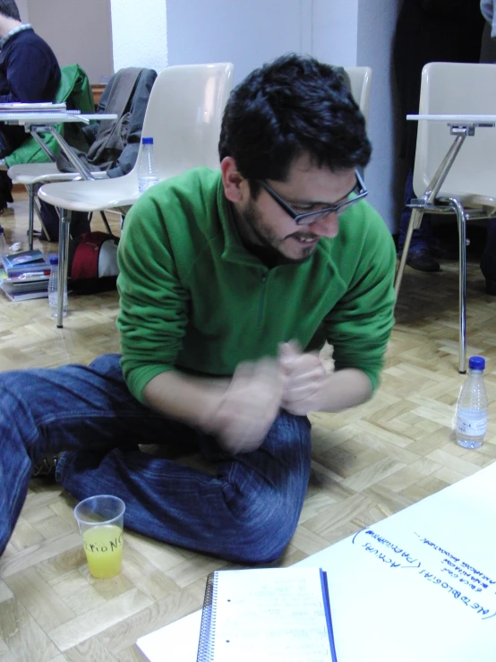 a guy sitting on the floor holding a cell phone