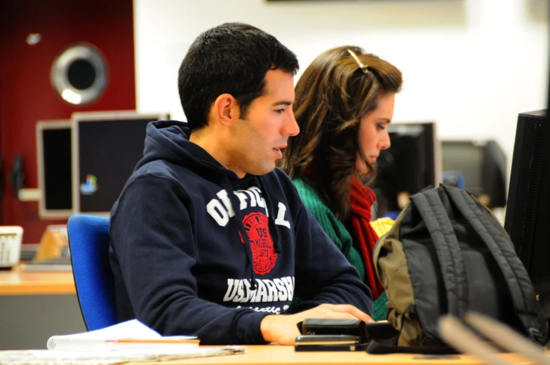 a couple of people in front of a laptop computer