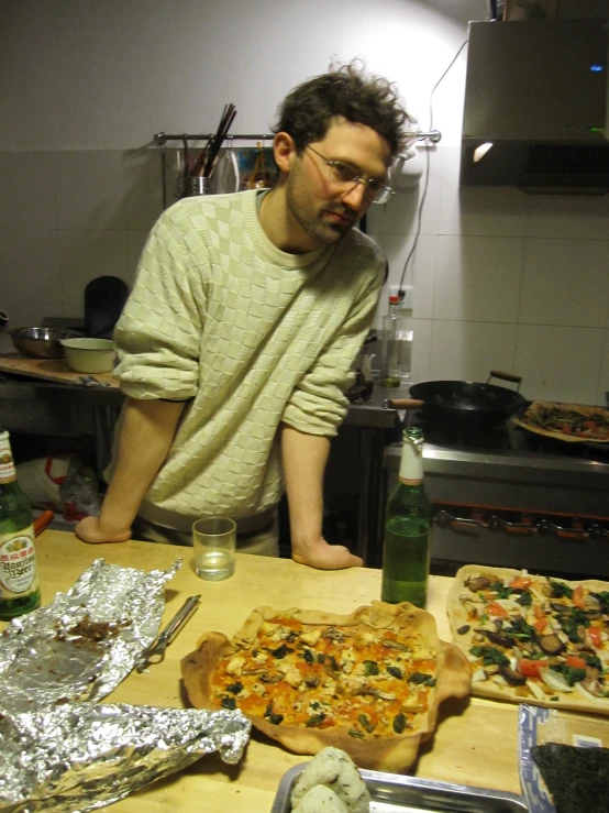 man at counter in kitchen preparing to make pizza