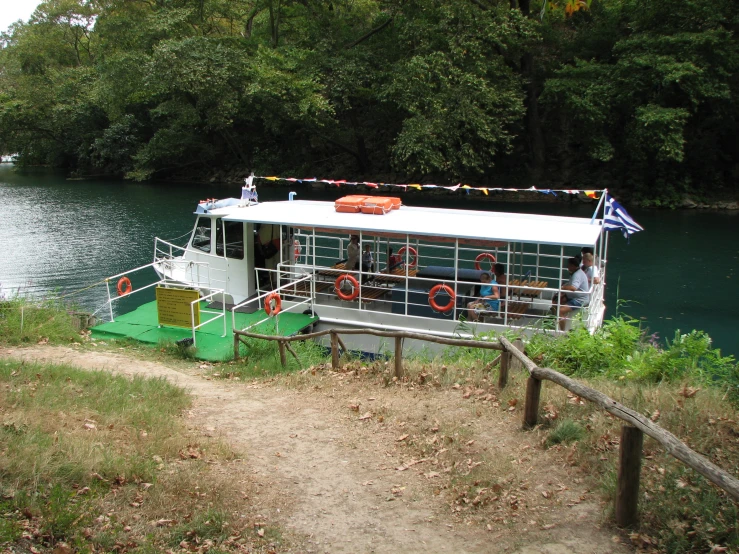 a boat docked on a river by the shore