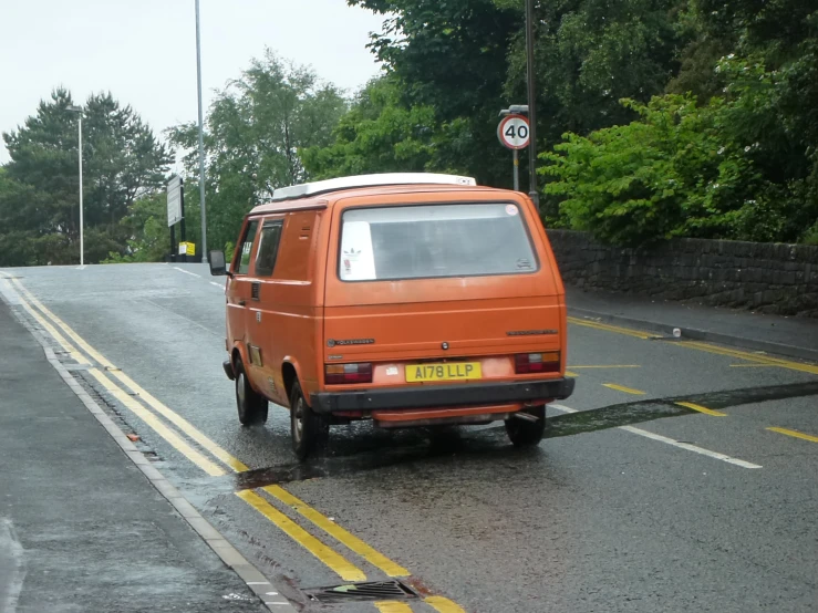 an orange van is stopped at the side of the road