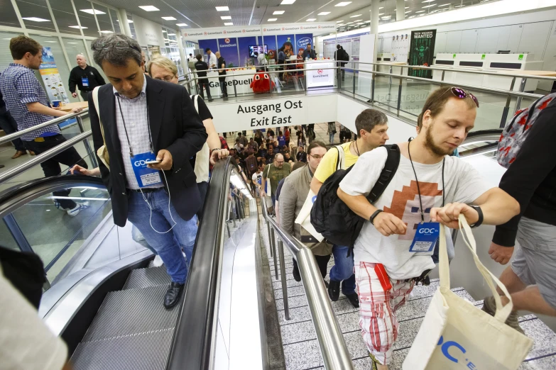 some people with their luggage riding on an escalator