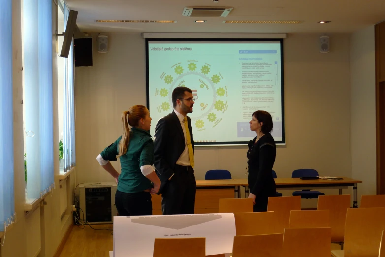 people with a projector in a classroom with chairs