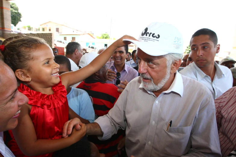 a little girl touches the forehead of an old man