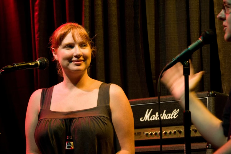 two people singing into a microphone in front of a musical instrument