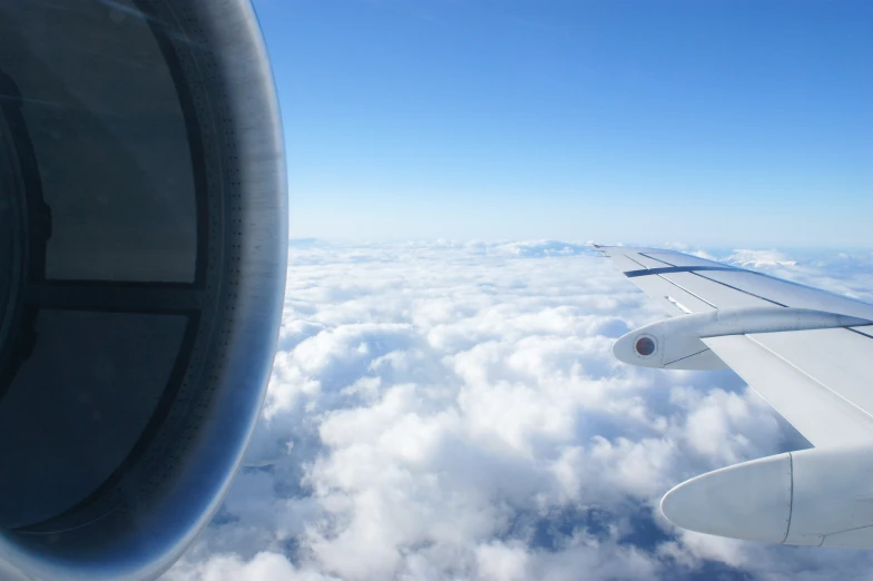 an airplane wing flying over a sea of clouds