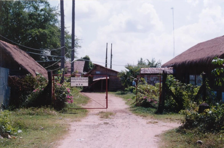 a dirt road is between two old houses
