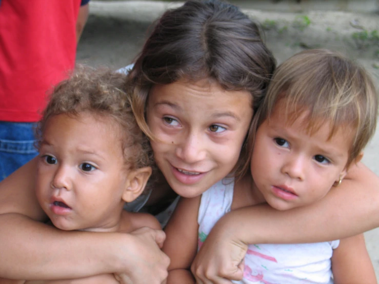 three little girls hugging on each other