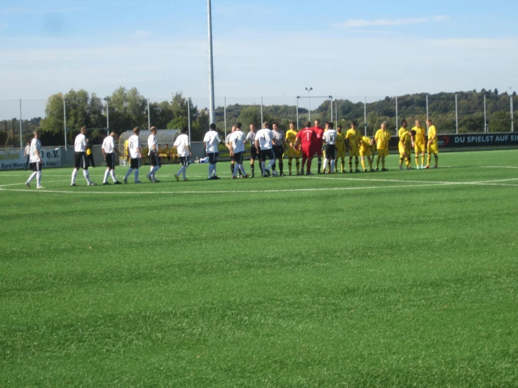 several soccer teams stand in front of a goal during a game