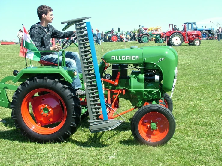 a person sitting on a green tractor in a field