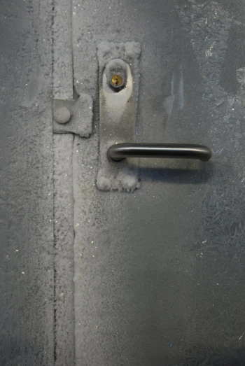 the door is open and the handle has snow on it