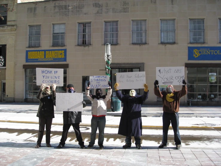 a group of people hold signs in front of a building