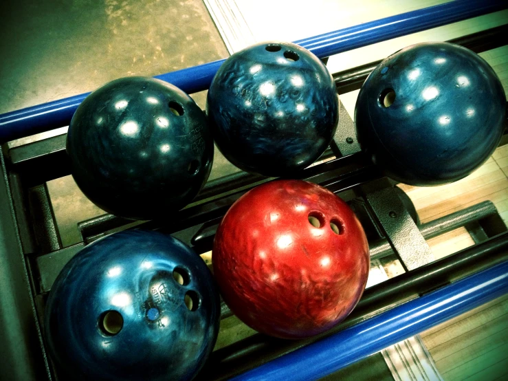 a group of four bowling balls sitting in a row