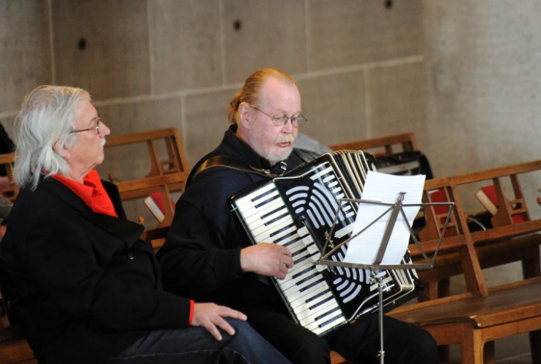 an older man and a woman playing a musical instrument