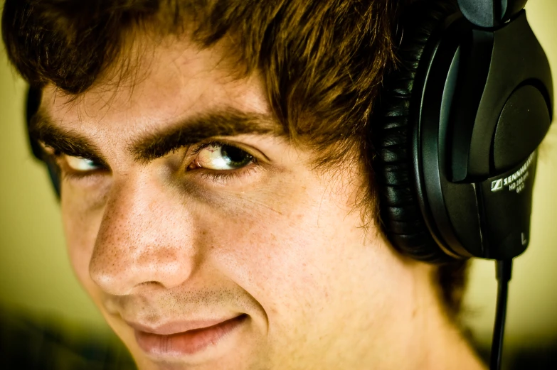 a man smiles while wearing headphones in his ears