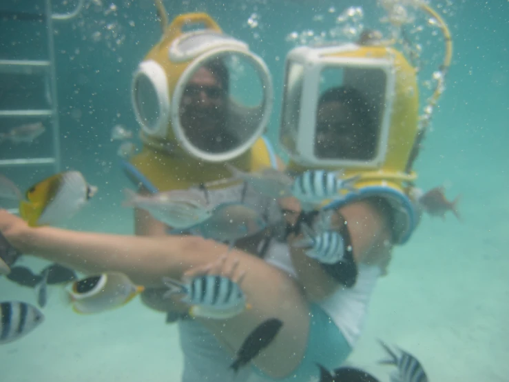 a couple of people under water wearing helmets and goggles