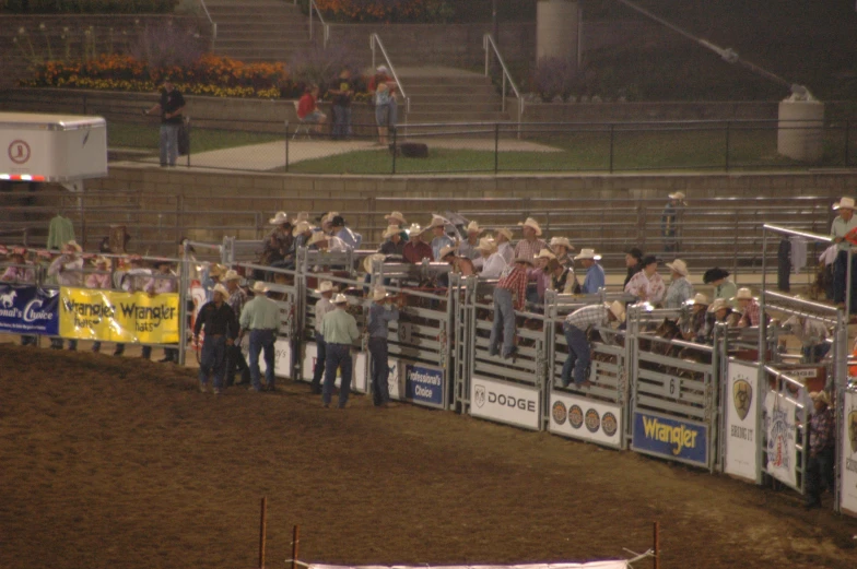 a group of men are standing next to a fence