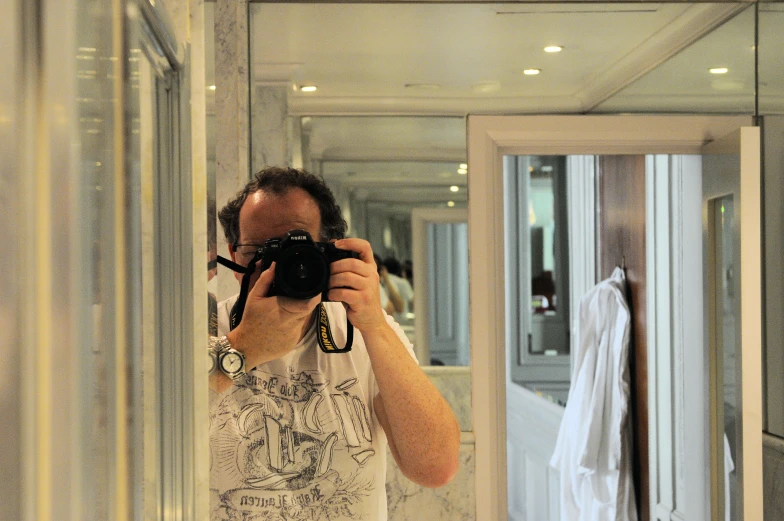 a man taking a po with a camera in a bathroom