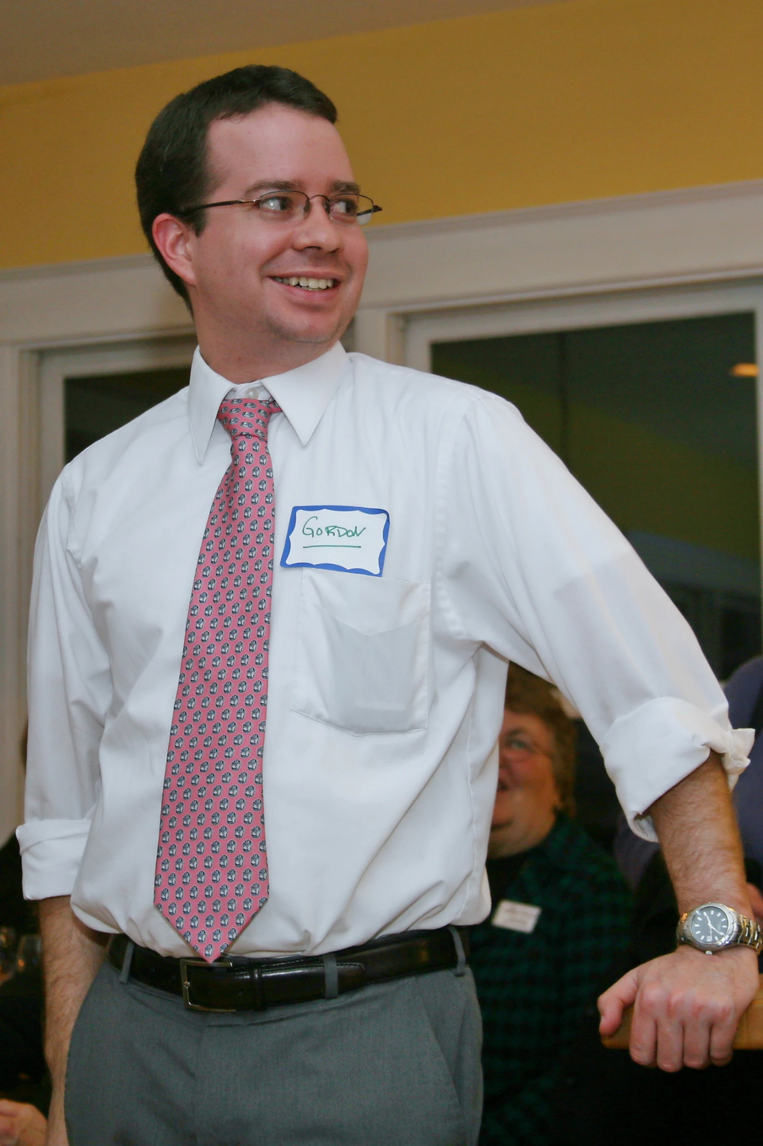 a man wearing a tie and white shirt is smiling