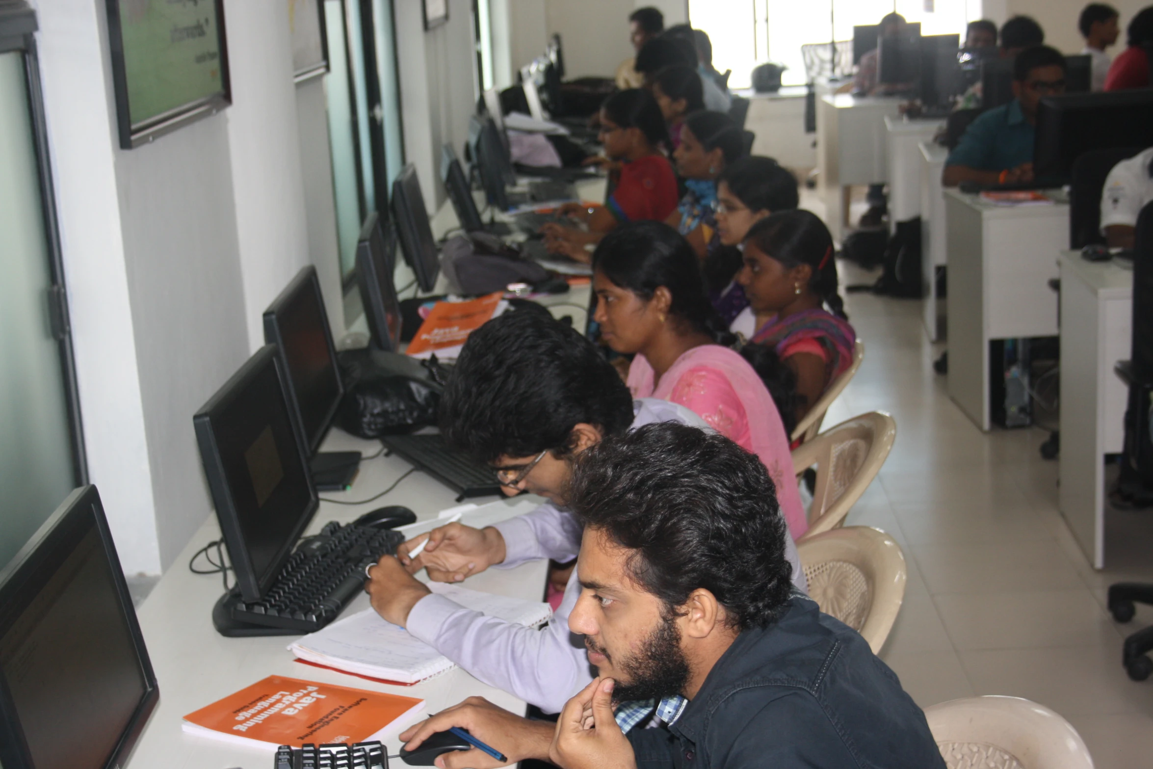 an office scene with focus on people sitting at tables and computers