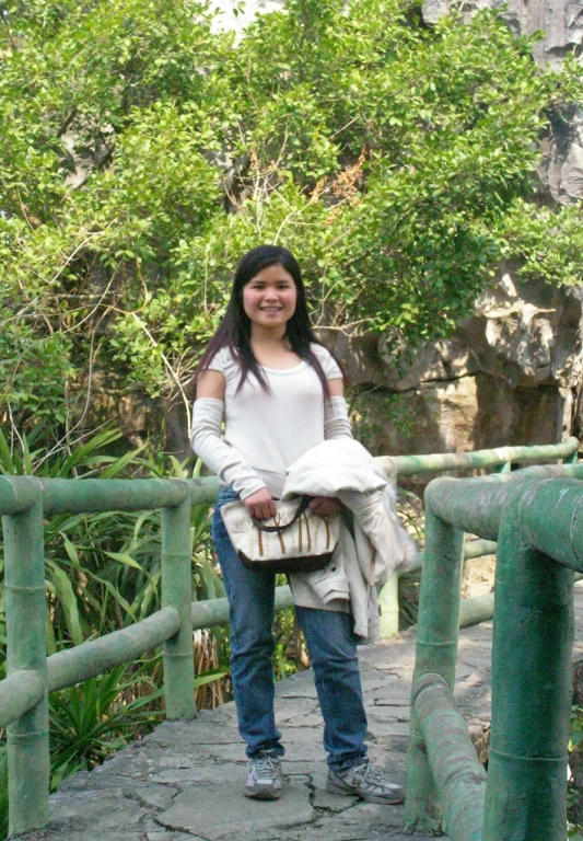 a woman on a bridge is holding onto her purse