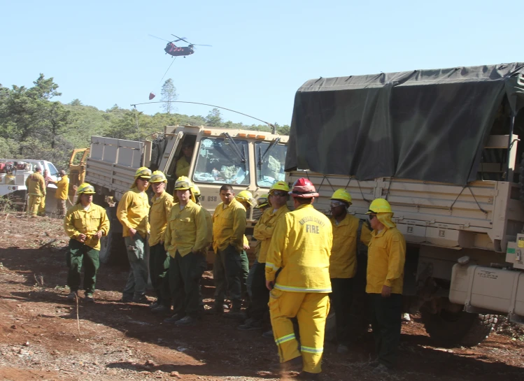 some very pretty firefighters standing together beside a big truck