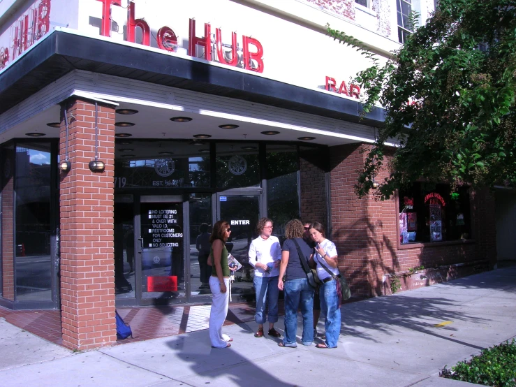 a group of people standing outside of the hurb