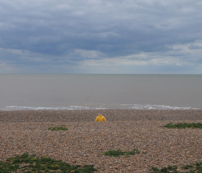 a yellow object on the shore with water in the background