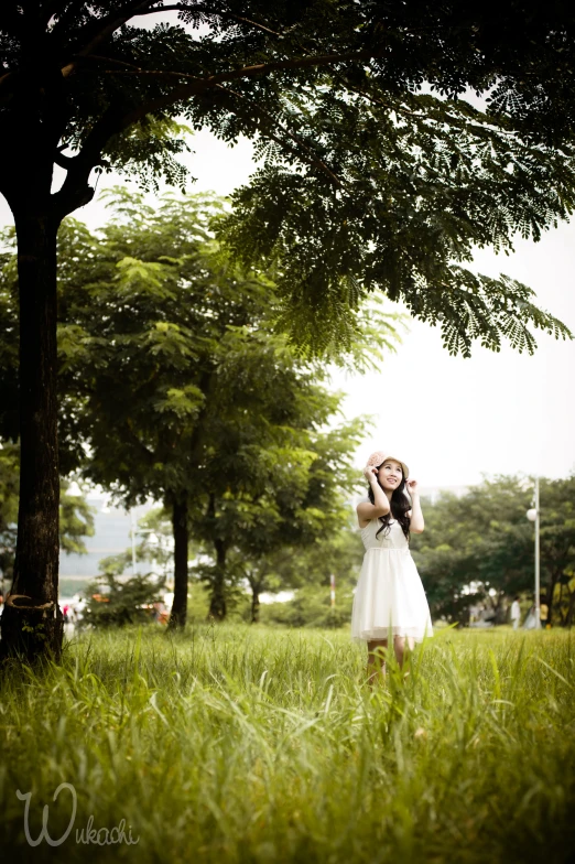 the girl is talking on her cell phone in the park