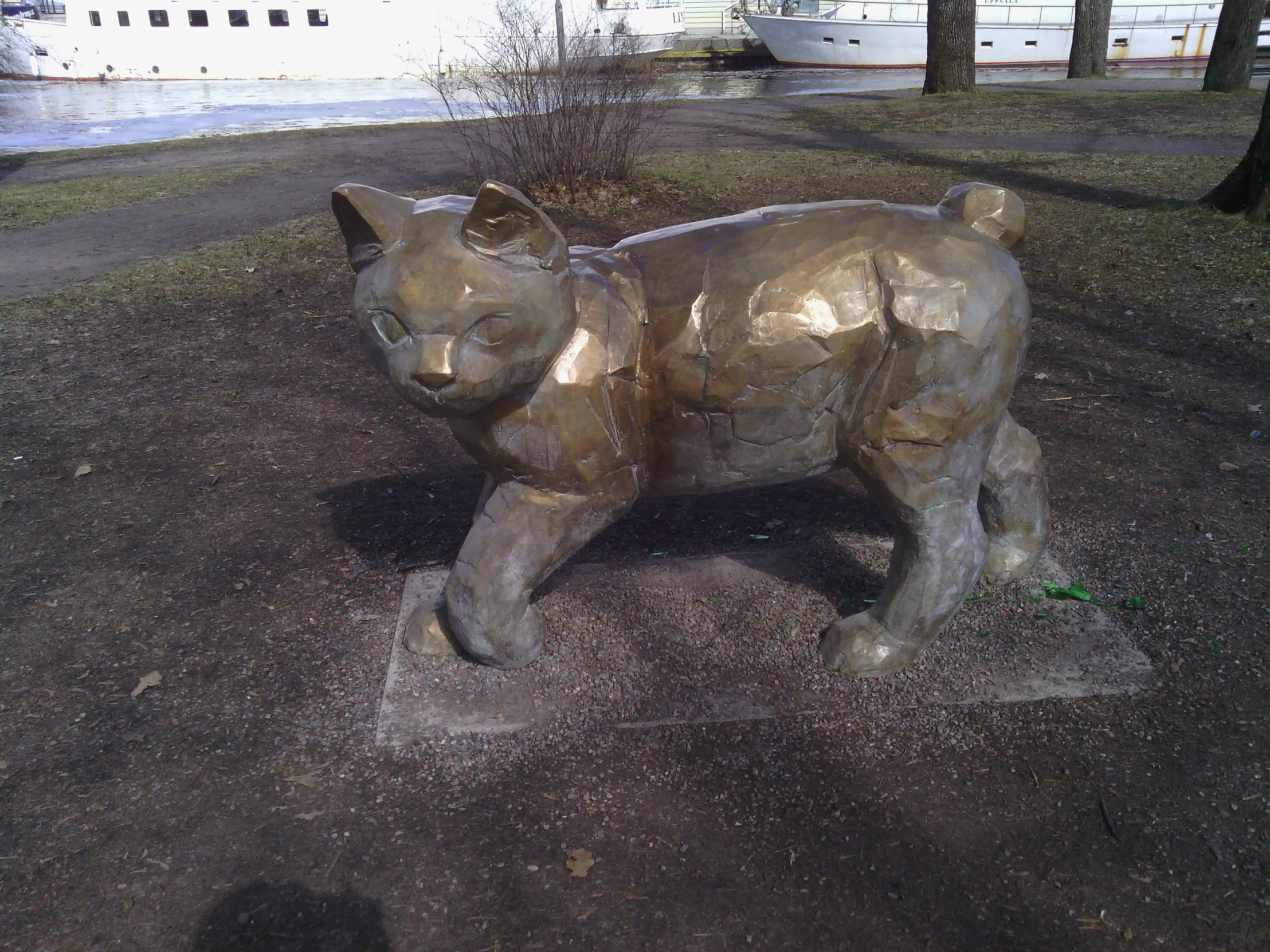 a statue of a bear in the middle of some grass