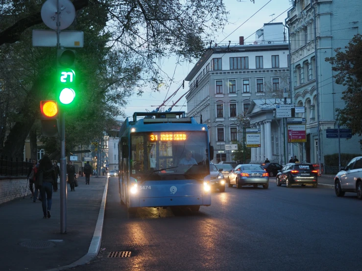 a bus driving down the street at dusk