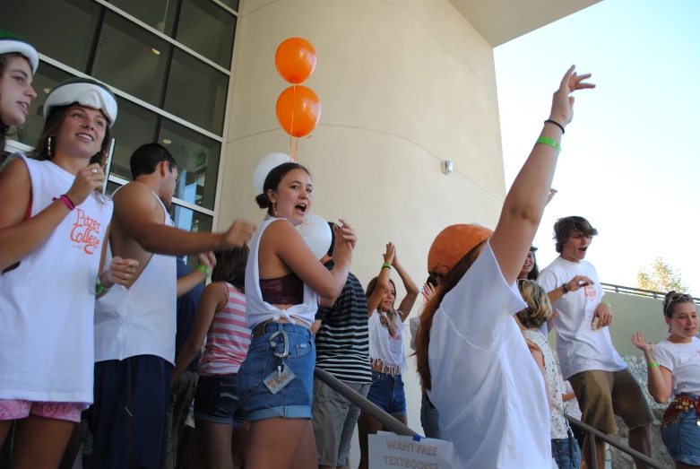 a group of people celeting in front of a building