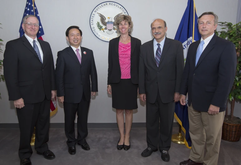 four men in business suits standing next to each other