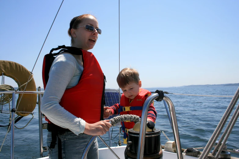 a woman and a child on a boat looking at a hydrant