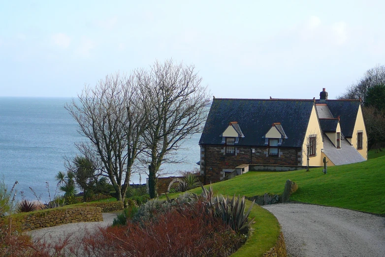 a house with three chimneys facing towards the ocean