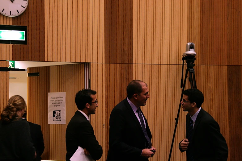 men standing next to each other in front of wooden walls