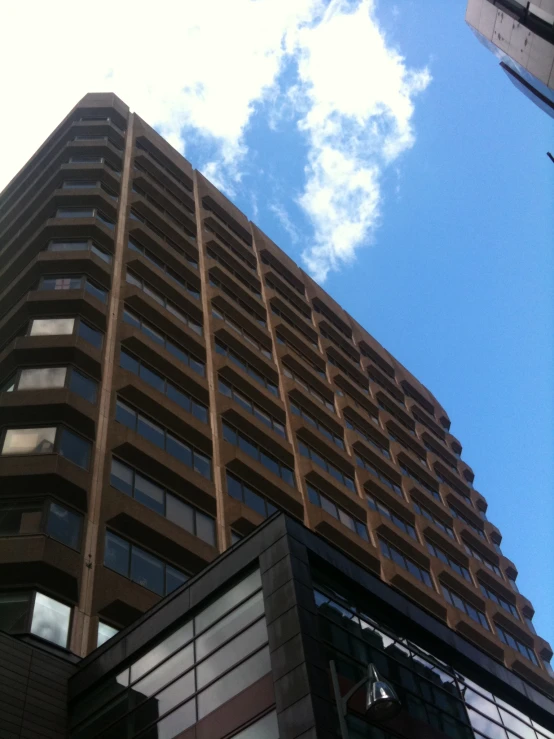 an upward view of a building in front of a cloudy sky