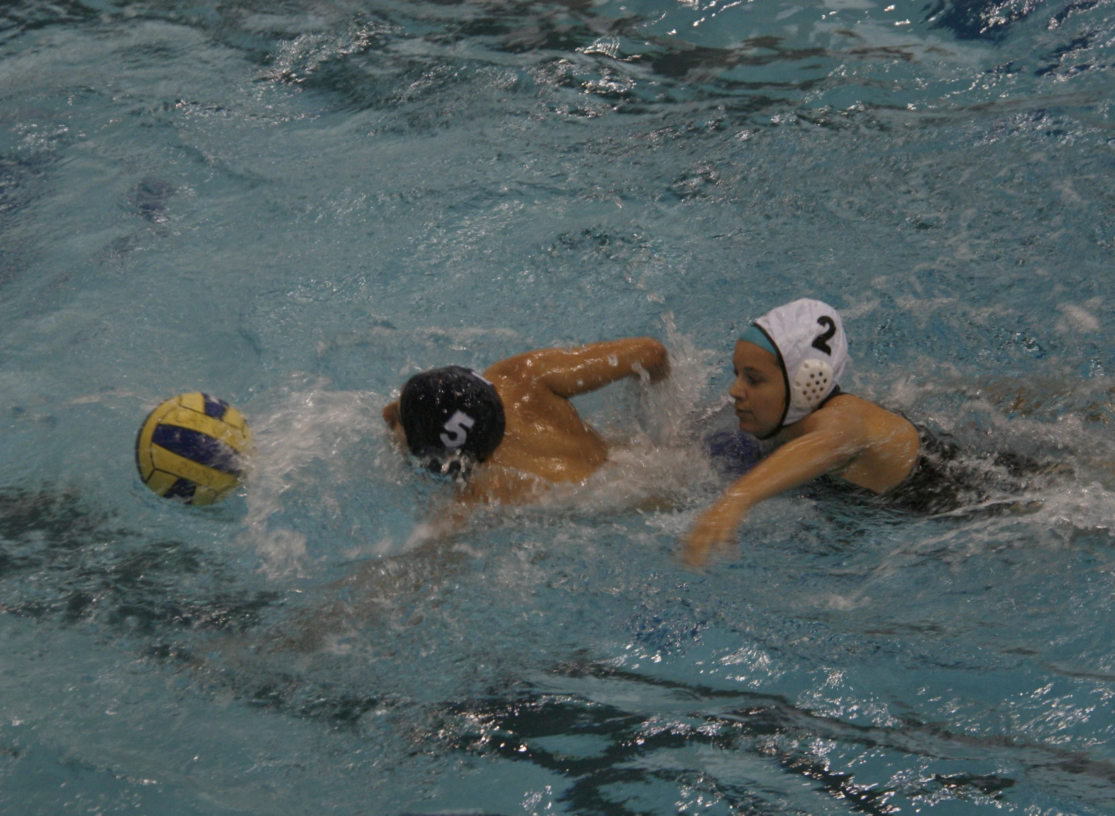 two people playing soccer in the water