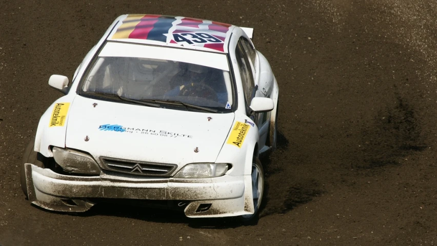 an automobile race car sitting on the dirt