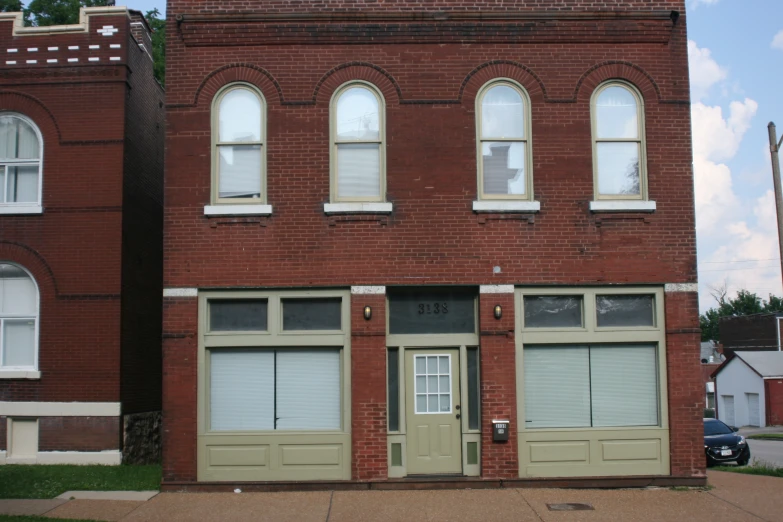 an old brick building with doors open on a street corner