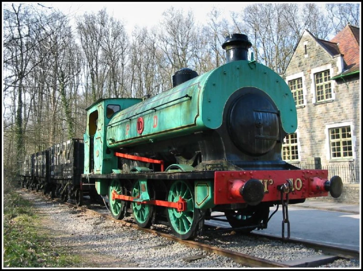 an old green train sitting on the tracks