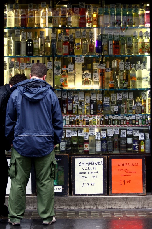 two men are standing in front of a display of alcohol bottles