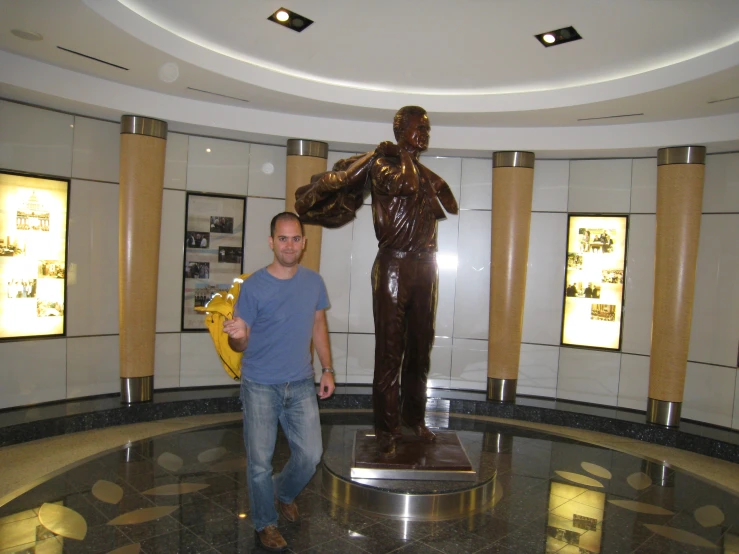 a guy holding a banana in front of a large statue