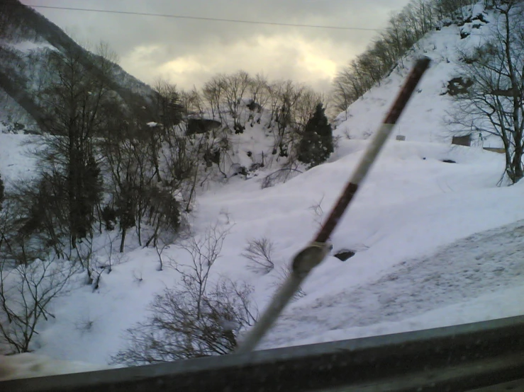 a snowy landscape with trees and mountains in the distance