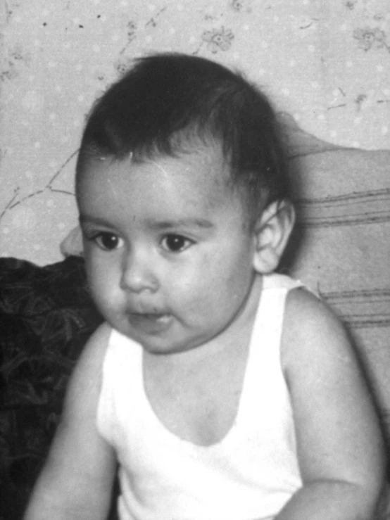 a baby boy with a diaper sitting in a chair