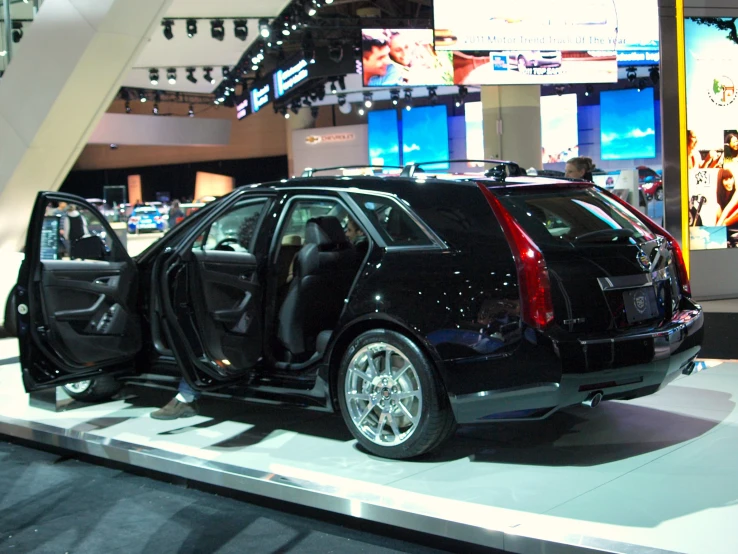 a car with the door open on display in a room