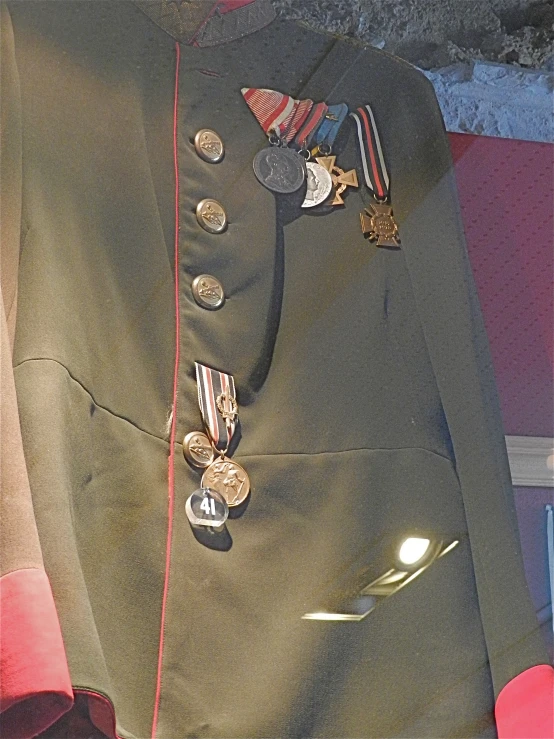 an uniform worn with medals is being displayed